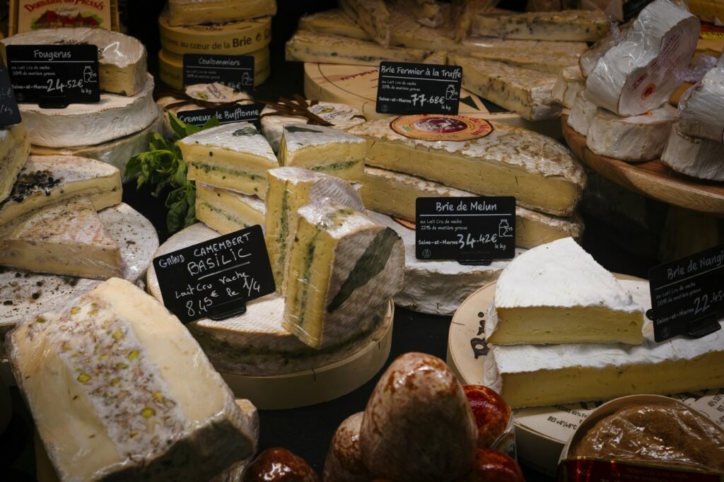 a variety of cheeses are displayed in a display case