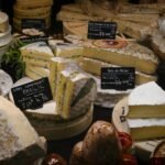 a variety of cheeses are displayed in a display case